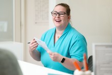 Fr. Lange lacht während sie an der Rezeption arbeitet