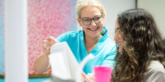 Fr. Lang erklärt einer Patientin etwas während einer Behandlung